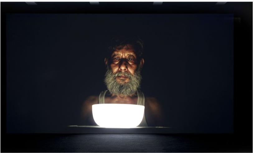 Catching the Green Ray — exhibition render: a darkened room where a projected portrait glows above a lit basin.